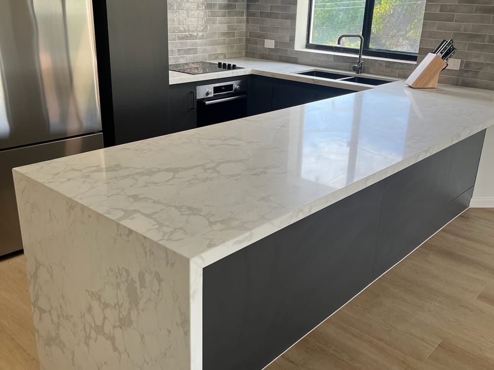 Kings Beach kitchen renovated by Elite Renovations — charcoal cabinetry and Calacatta stone island