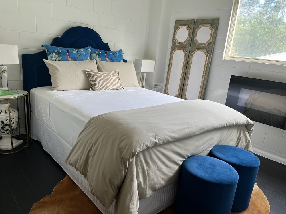 Maleny garage converted to a studio by Elite Renovations — styled bedroom against the original block wall
